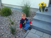 Seitlich der Treppe Pflanzung mit buntem Granitschotter bedeckt