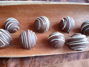 Triple Chocolat Cakeballs; herbe Kuchenbällchen überzogen mit Vollmilchkuvertüre und einer Verzierung aus weißer Schokolade