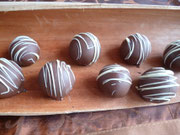 Triple Chocolat Cakeballs; herbe Kuchenbällchen überzogen mit Vollmilchkuvertüre und einer Verzierung aus weißer Schokolade