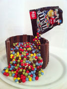 'Anti-Gravity-Cake', die schwebende M&Ms Verpackung, darunter Oreo Kuchen (dunkler Schokokuchen, gefüllt mit weißer-Schokolade-Buttercreme)