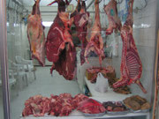 Schaufenster einer Metzgerei, Doha. Von links nach rechts: Rindfleisch, Kamelfleisch, Rindfleisch, Schaffleisch. Darunter eine Reihe von inneren Organen. Und jede Menge Fliegen.