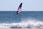 Un planchiste en plein windsurf sur les vagues de la manche, au large d'une plage de la Côte d'Opale. Idéal pour les amateurs de sports nautiques séjournant dans notre gîte.