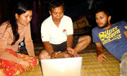 Sarin and his wife using Wifi connection from hotel next door at their house in Battambang