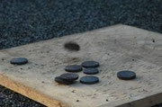 Palet sur planche : Un jeu d’équipe où il faut lancer les palets en fonte sur la planche. Un jeu convivial comme la pétanque    A partir de 10 ans