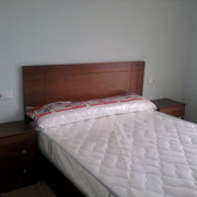 Cama de madera en nogal .