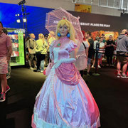 Das Bild zu Männerquatsch Podcast Folge 196 zeigt ein Prinzessin Peach Cosplayer vor dem Stand von Microsoft auf der Gamescom 2025.