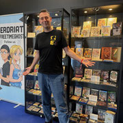 Das Bild zu Männerquatsch Podcast Folge 196 zeigt Manuel mit seiner Tales of Vitrinenausstellung in der Retro Area auf der Gamescom 2025.