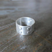 photo d'une bague large en argent avec 8 rivets à plat