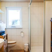 Das helle Badezimmer mit Dusche, Waschtisch und WC