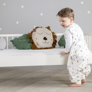 Kind im Schlafsack to go von Träumeland stehend vor Kinderbett