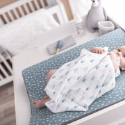 Baby im Musselintuch auf Wickelauflage von Träumeland