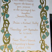 hand-decorated wedding invitation in gold copperplate script