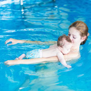 Schwimmtrainerin mit Baby auf den Armen