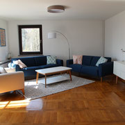 Blick ins Wohnzimmer mit zwei komfortablen Sofas und einem Sessel