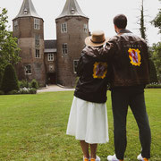 oudere bruid in stoer jack met beschildering van eigen ontwerp, aim your wedding