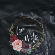 tekst met bloemen op leren jasje bruid, aim your wedding