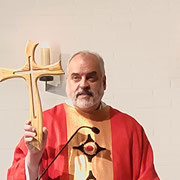 Pfarrer Busche weist auf die besondere Form des Kreuzes hin