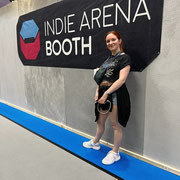 Das Bild zur Folge 130 des Männerquatsch Podcast, zeigt Ines vor der Indie Arena Booth auf der Gamescom 2022.