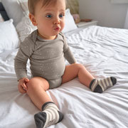 Baby im Elternbett mit Erstlingsocken & Babybody von  LÄSSIG