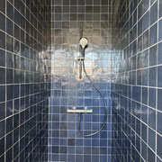 Pose droite d'une faience 10x10 bleue dans une douche
