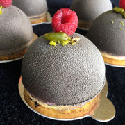 Schoggikuppel gefüllt mit Beeren-/Pistazienmousse auf Biskuit