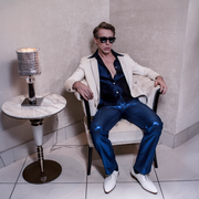 Ottaviano Blitch, Italian actor and performer, relaxed editorial fashion portrait seated with sunglasses in a bright minimal interior, attore performer italiano servizio moda editoriale
