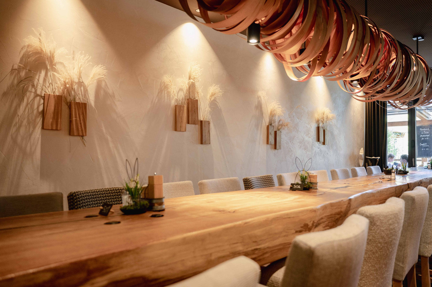 Long communal table made from a single tree trunk in the “Naschwerk” at Boutique Hotel Werdenfelserei, Bavaria