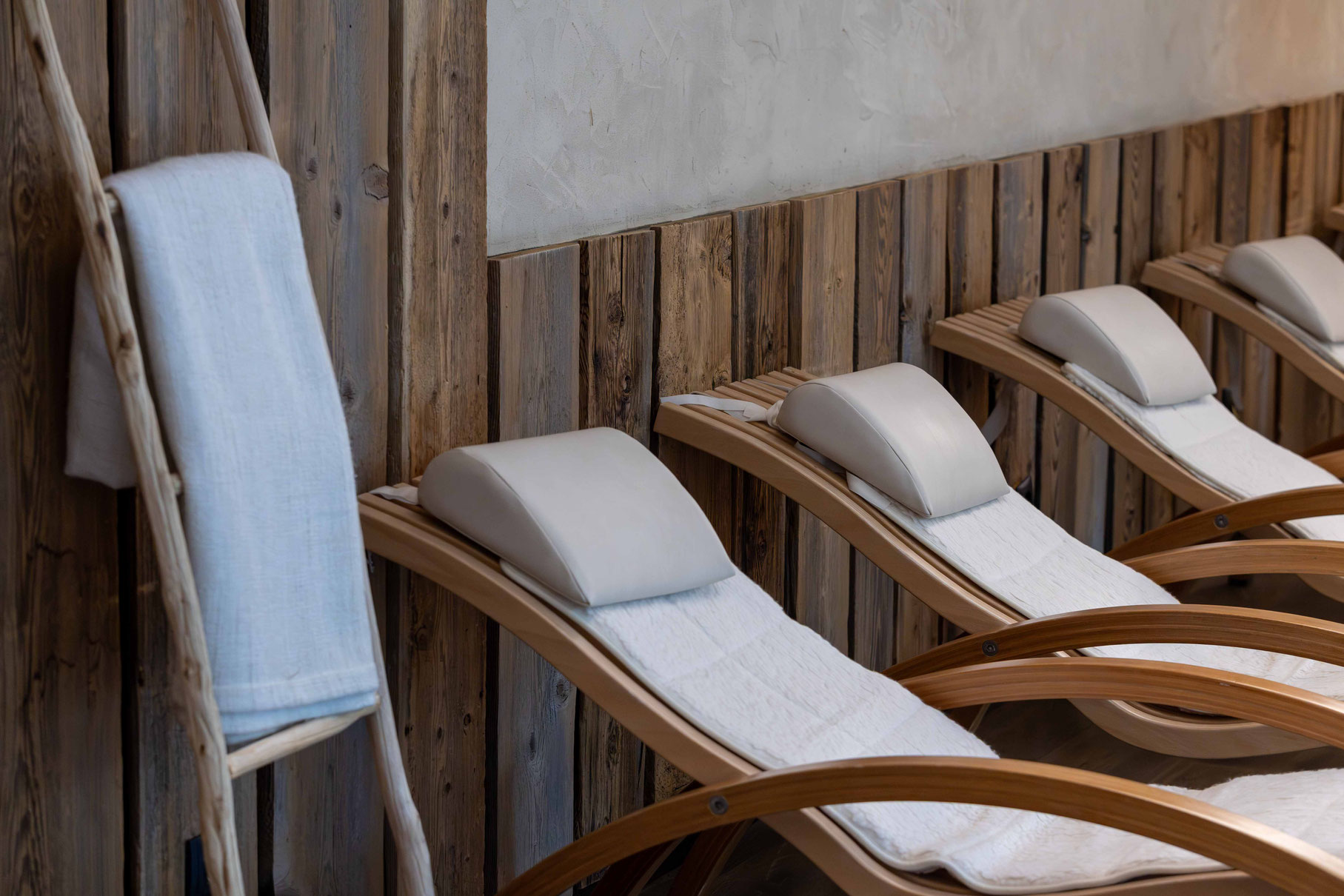 Ergonomische Relaxliegen aus Holz im Wellnessbereich des Boutiquehotel PETRUS in Reischach-Bruneck • Südtirol, geschaffen für erholsame Ruhepausen in natürlicher Atmosphäre.