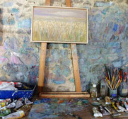 Tableau d'un champ de blé posé sur un chevalet, dans l'atelier du peintre