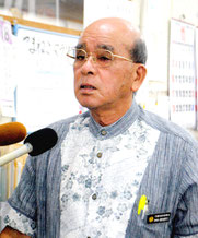 文科省の是正要求を受け、報道陣の質問に答える慶田盛教育長=18日午前、竹富町教育委員会