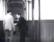 昭和18(1943)年映画　海軍兵学校2次試験終了を報告する場面。左から山内明、東野英治郎。奥に扉と窓が見えるので、北側校舎2階、手前が現・物理教室あたりで奥が現・生徒会室だろうか。