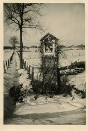 Oude foto zwart-wit. Een kapel aan een ondergesneeuwd weiland.