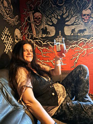 Girl with long dark hair holding a glass of beer in Zobens un Lemess bar in Riga