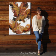 Photo de Caroline SIMON artiste peintre en Savoie à côté du tableaux d'intention sur toile Flamme 80 x 120 cm  