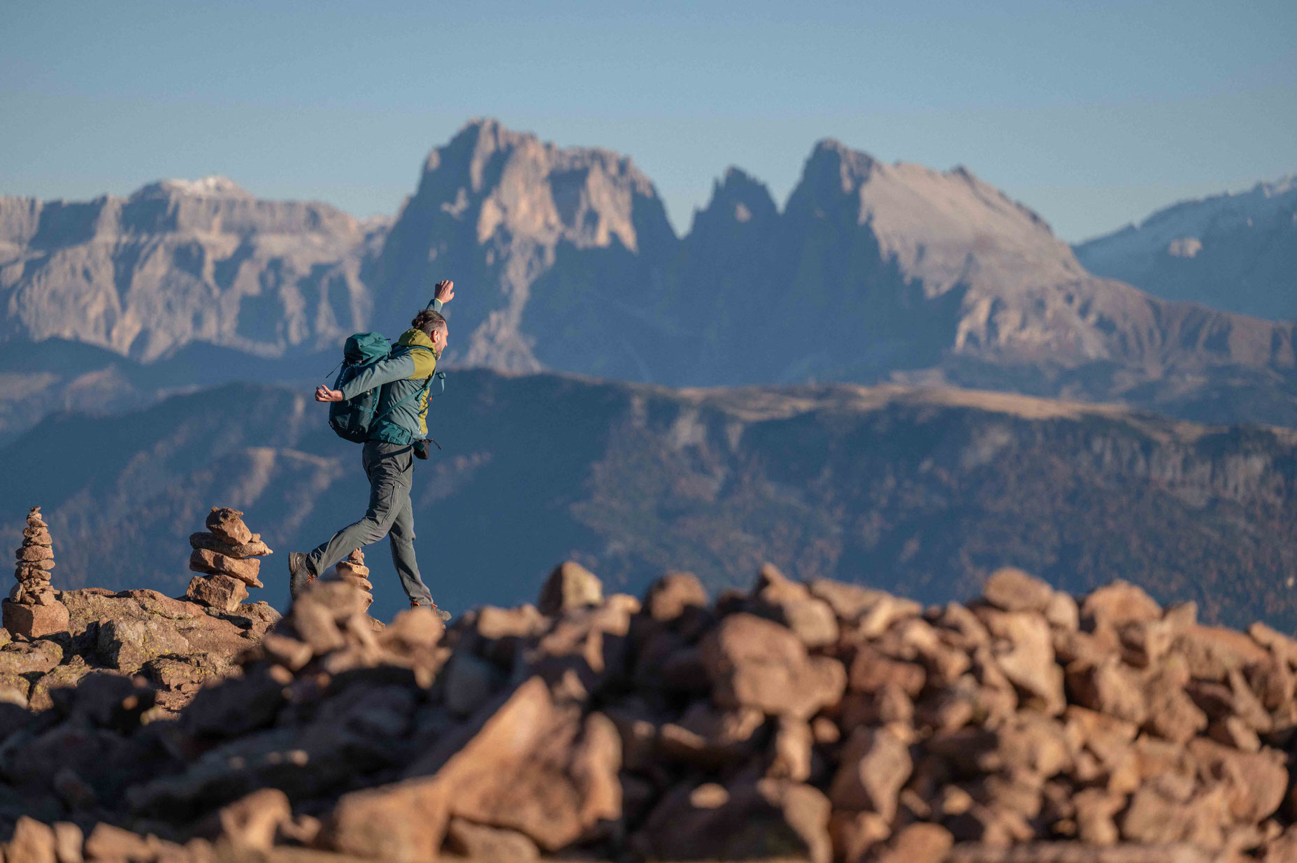 Person springt vor Freude am Rittner Horn in Südtirol mit Blick auf die Dolomiten und das Sonnenplateau Ritten.