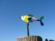 Bunter Metallfisch vor blauem Himmel
