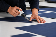 Japanese artisan precisely cutting fabric for a Made in Japan laptop bag