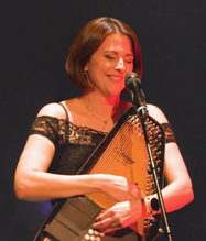 Kathleen Biaz chante et joue de l'Autoharpe sur une scène prestigieuse