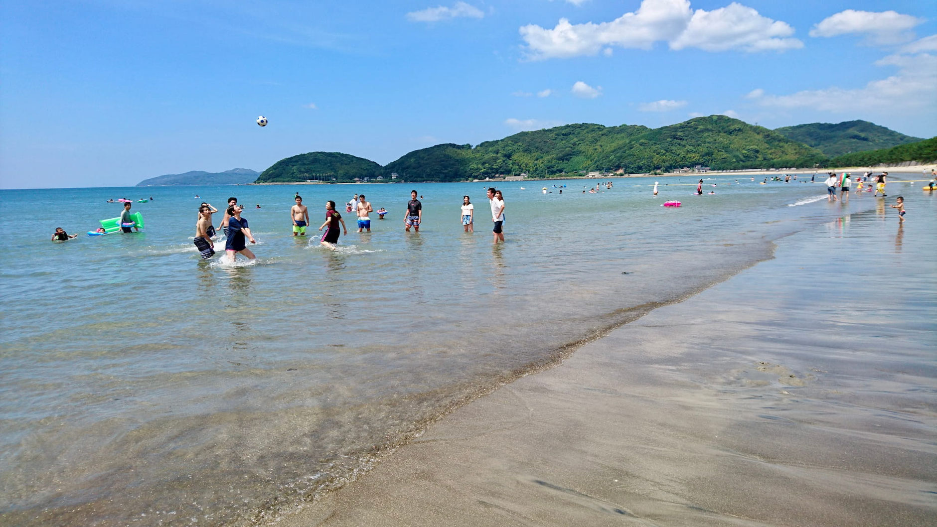 遠浅の深江海水浴場で海に入って遊ぶ人々