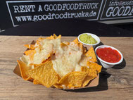 Mit Käse überbackene Nachos in brauner Pappschale mit 2 sparaten Dips