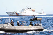 尖閣諸島周辺の日本領海内を航行する中国公船「海警」と海保のゴムボート(手前)=2013年、仲間均市議提供