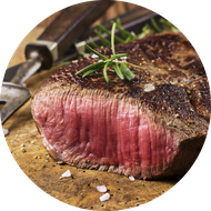 Medium Rare Steak mit Thymianzweig und Messer auf einem Holzbrett