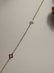 MOKOŠEV luxury jewelry, fine gold bracelet with two small clover elements on a neutral background.