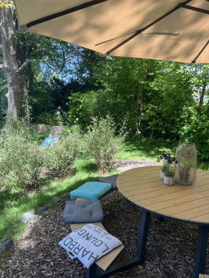Detailaufnahme mit Tisch, Bänken und Deko im Garten