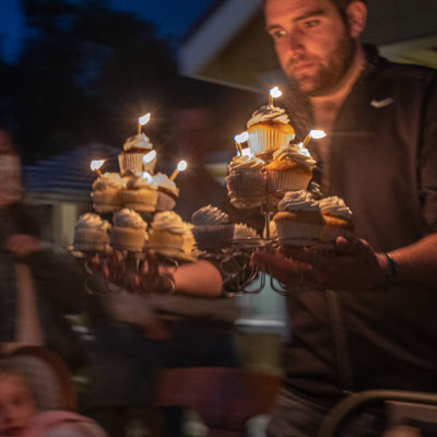 David's 90th birthday party - Zach with birthday cupcake tower