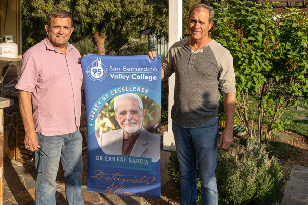 David's 90th birthday party guests - Tim and Pat holding banner acknowledging their father