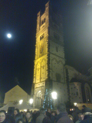 Der Wintermond wacht über den Weihnachtsmarkt.