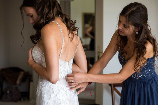 Anziehen des Hochzeitskleids durch die Trauzeugin