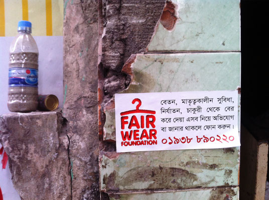 Ein Aufkleber der Fair Wear Foundation an der Wand des Gewerkschaftsbüros NGWF in Dhaka