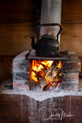 In the glow of a wood fire, a kettle brews coffee the traditional way—simple, grounded, and rich with the warmth of Costa Rican hospitality.